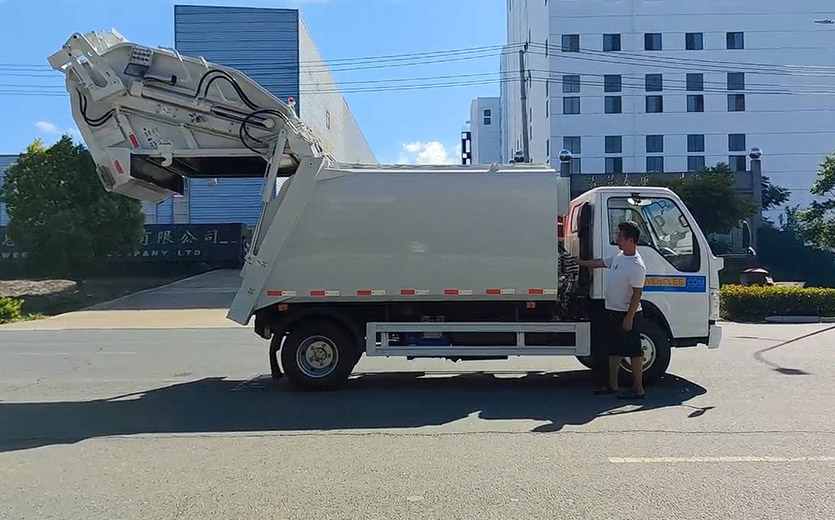 Camion à ordures compacteur à chargement arrière ISUZU ELF 130HP 7CBM
